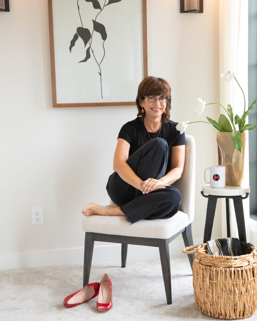 Wendy Theberge sits on a chair smiling